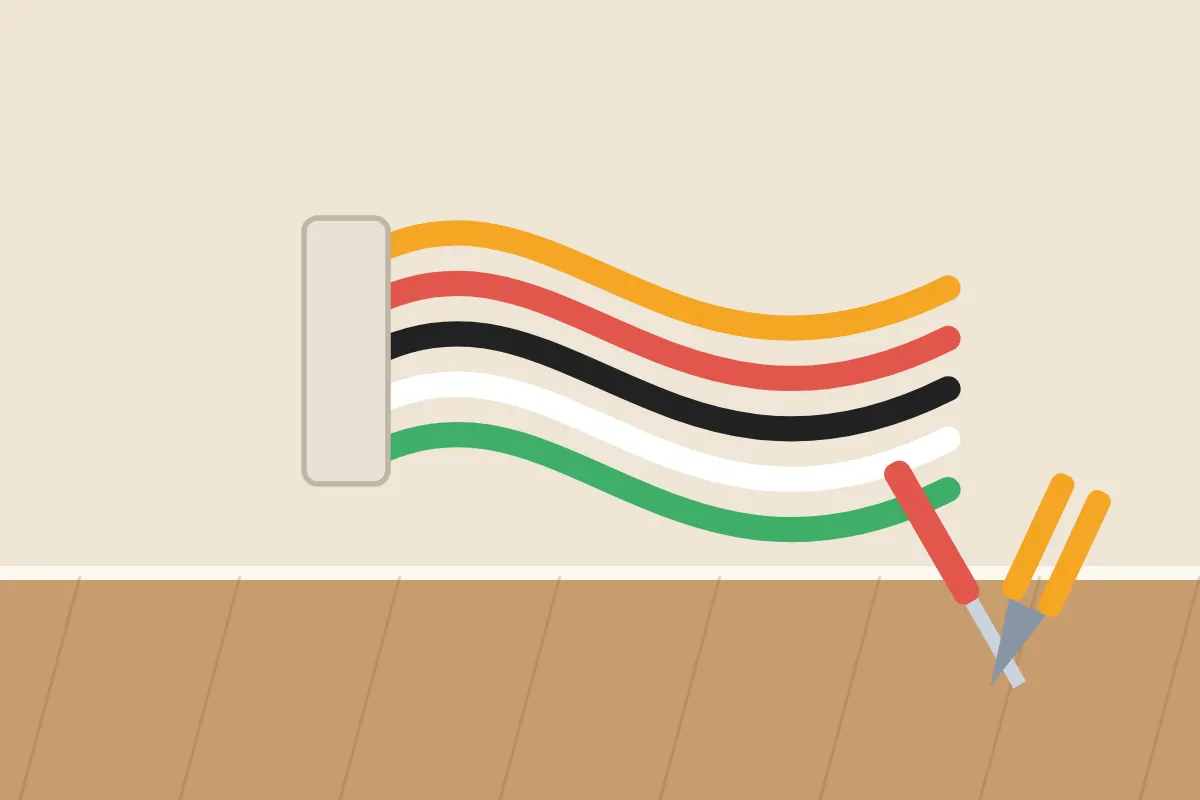 New electrical cables in several colors running from a wall box beside an electrician's tools