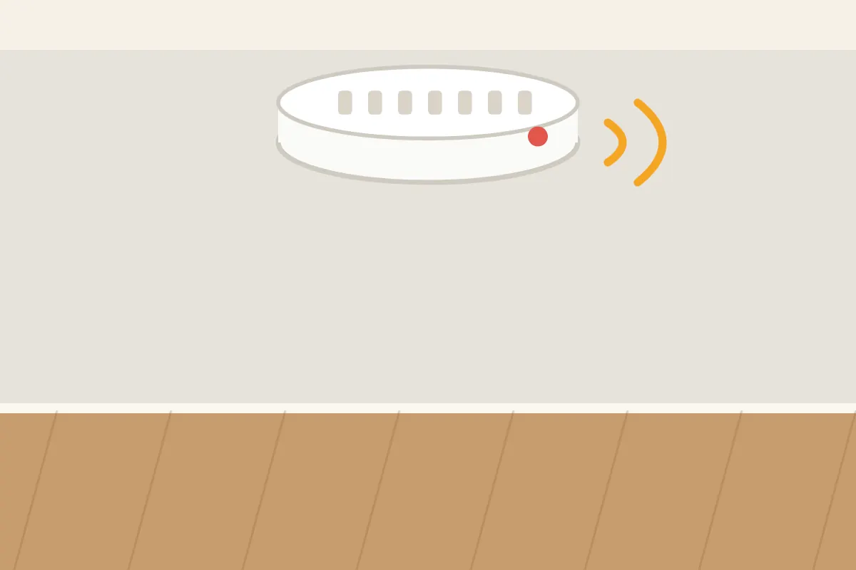 Ceiling mounted smoke alarm sounding with its indicator light on