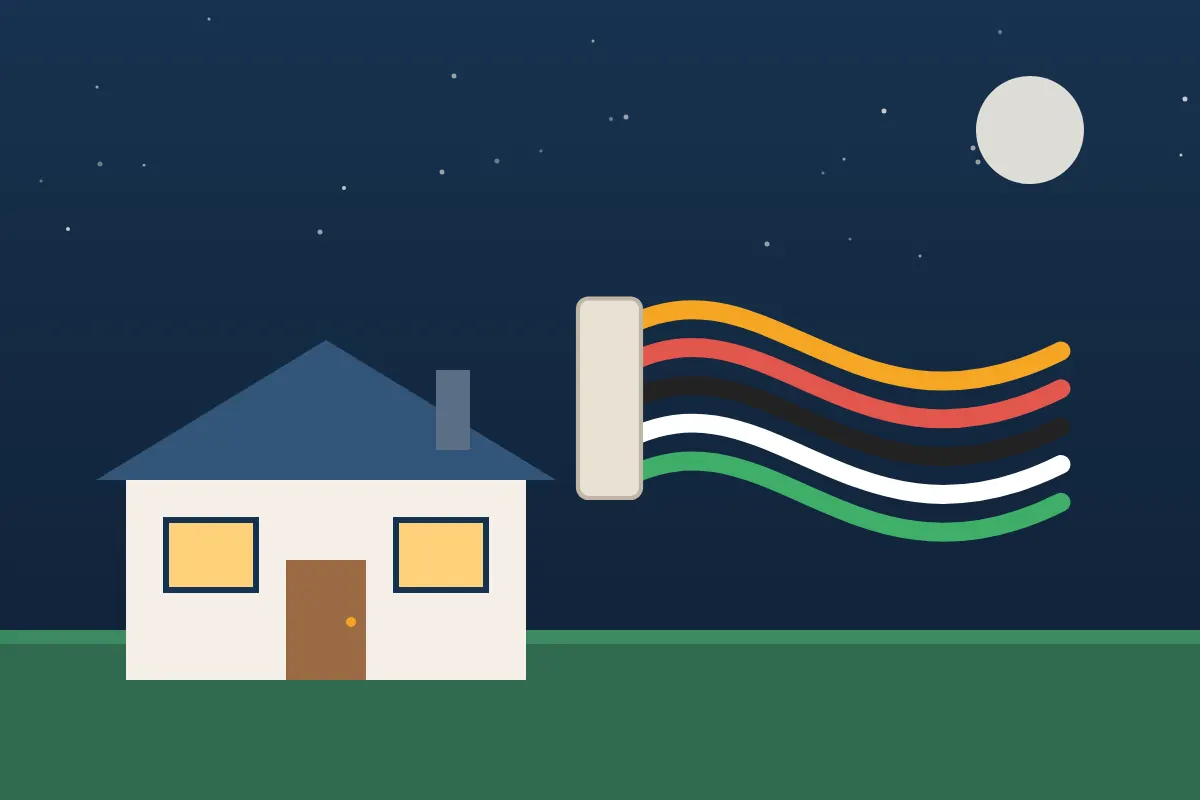 Suburban house at night with bundles of new colored electrical cable beside it